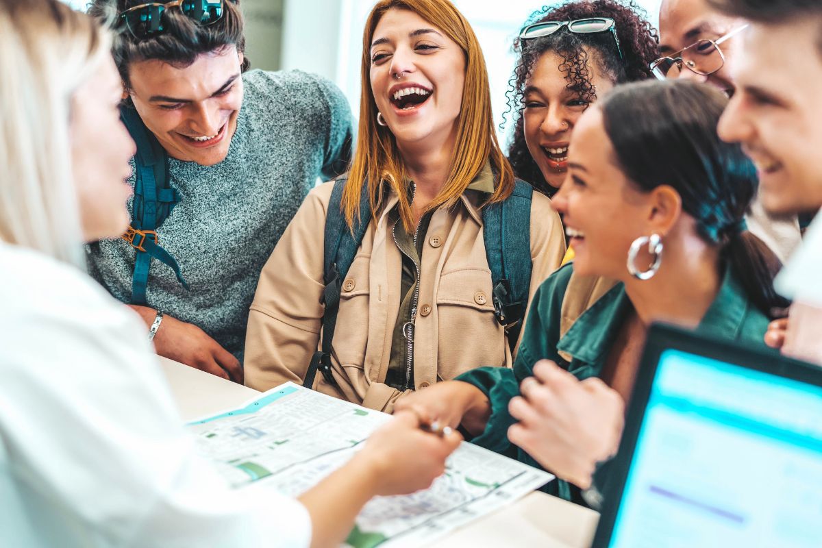 A group of young adults checking into a hotel.