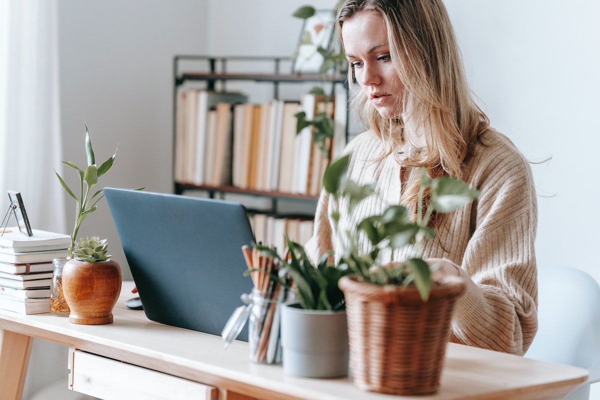 A woman sitting at a desk using a laptop.