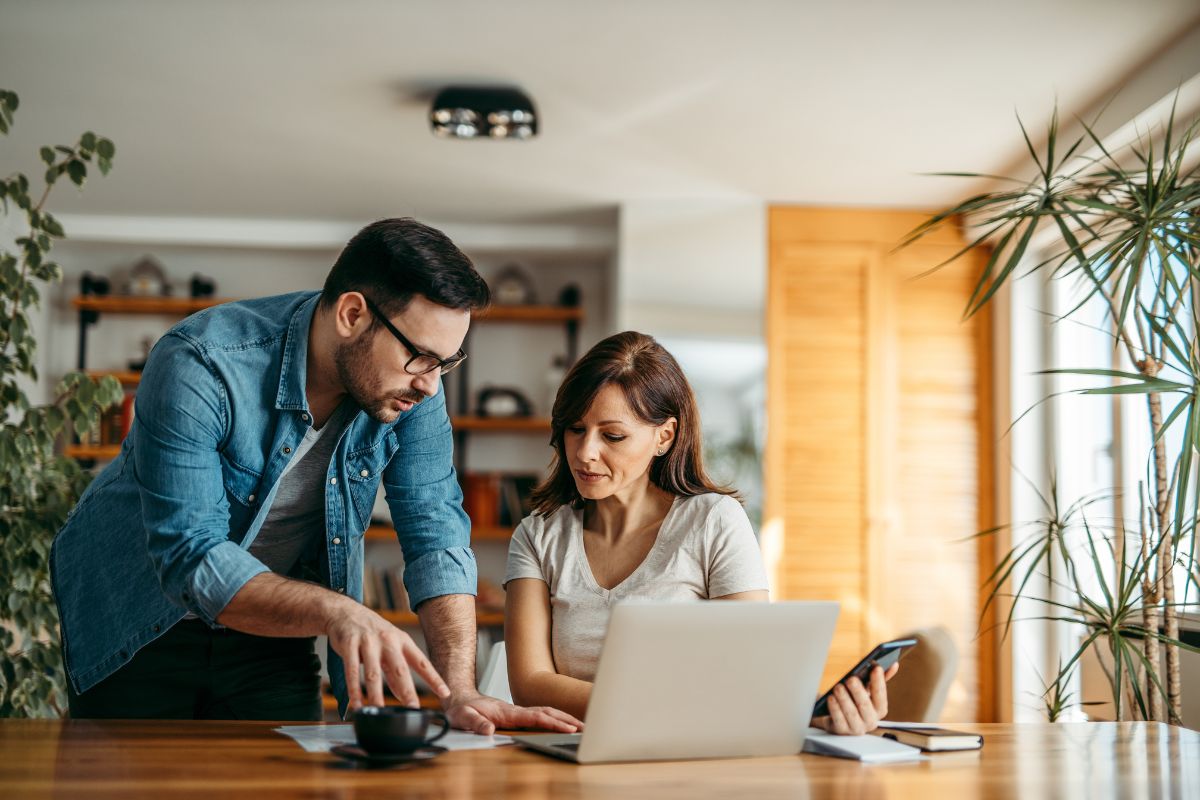 A man and a woman looking at online travel agencies on a laptop.