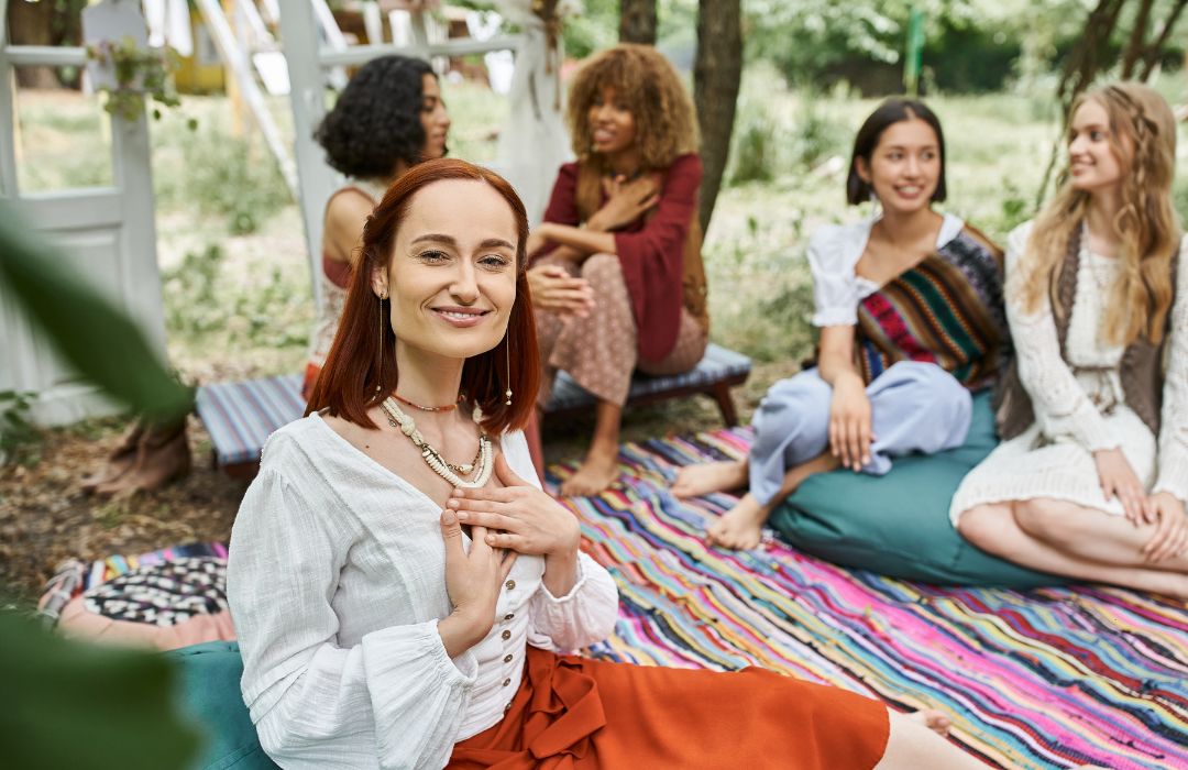 A wellness retreat leader sitting with a group of women.