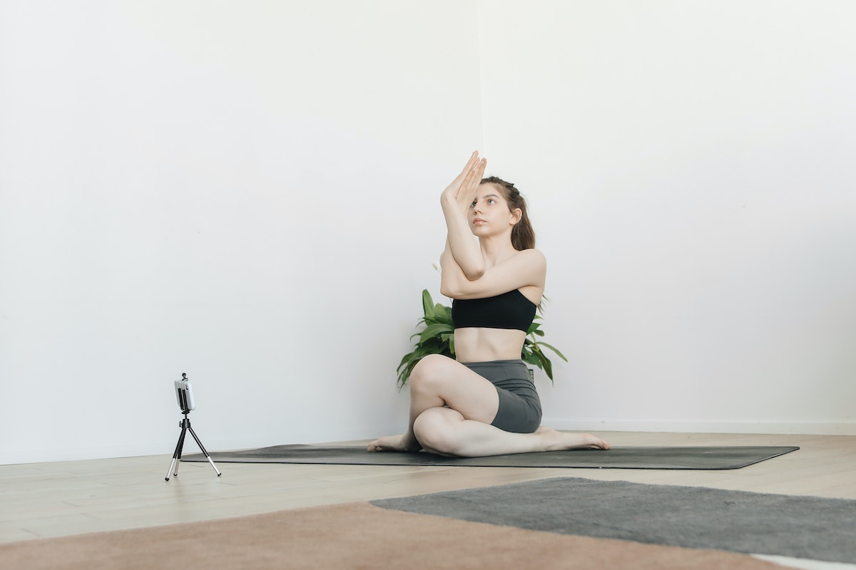 Yoga teacher conducting virtual yoga class at home on a video