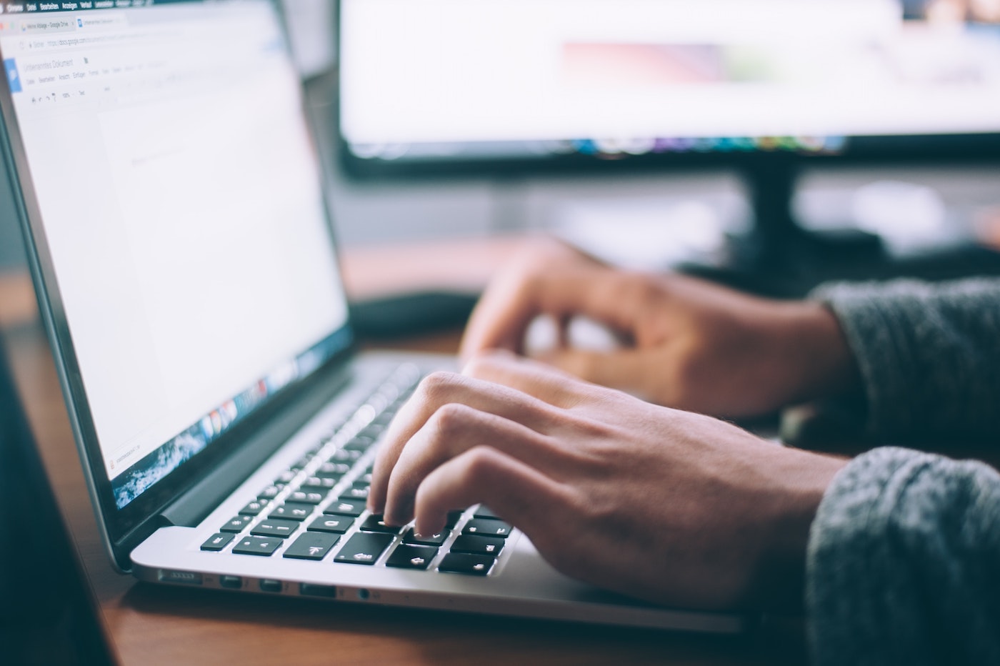 A person typing a welcome home email on a laptop.